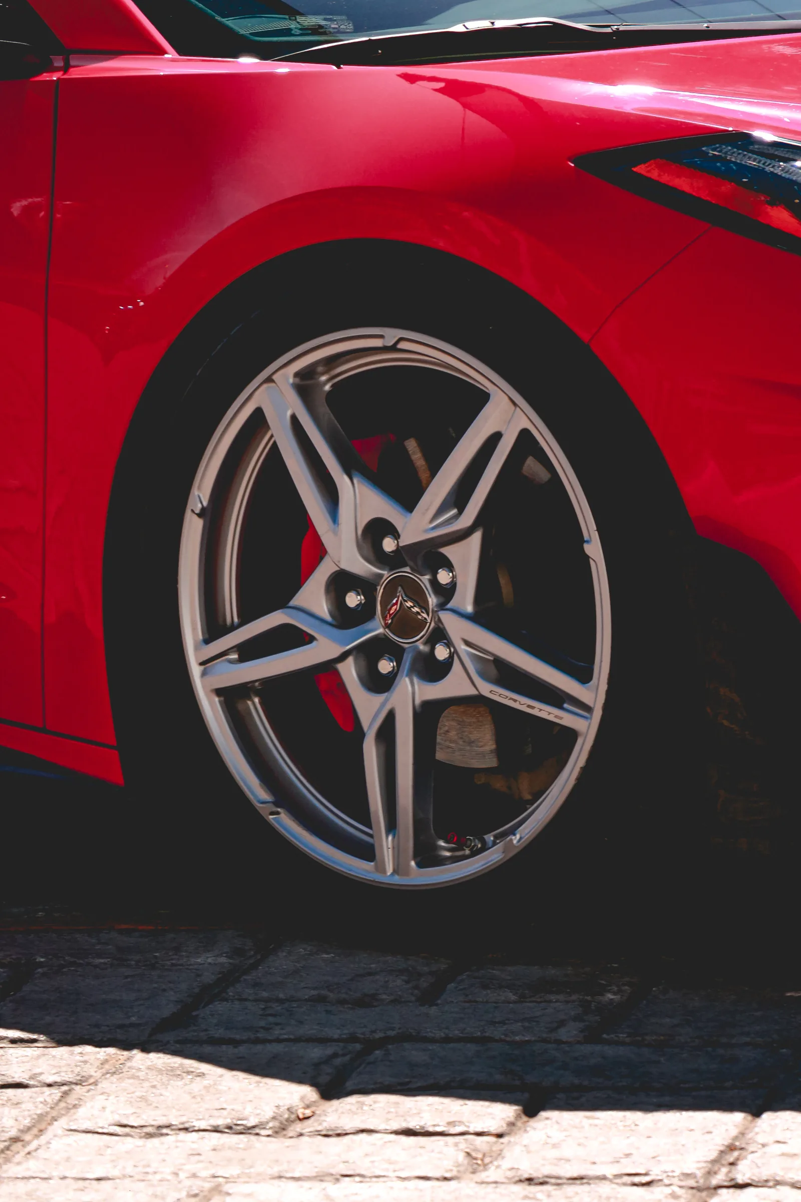 Rin trasero de un Corvette C8 rojo, con el logo de las banderas cruzadas al centro