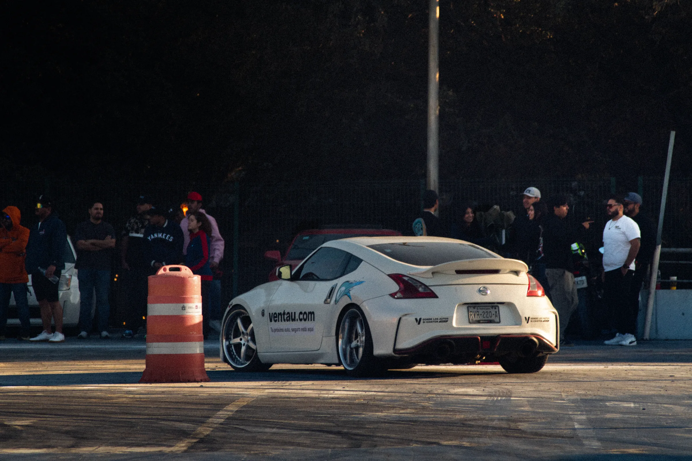 Un Nissan blanco frente a la gente que mira desde la orilla