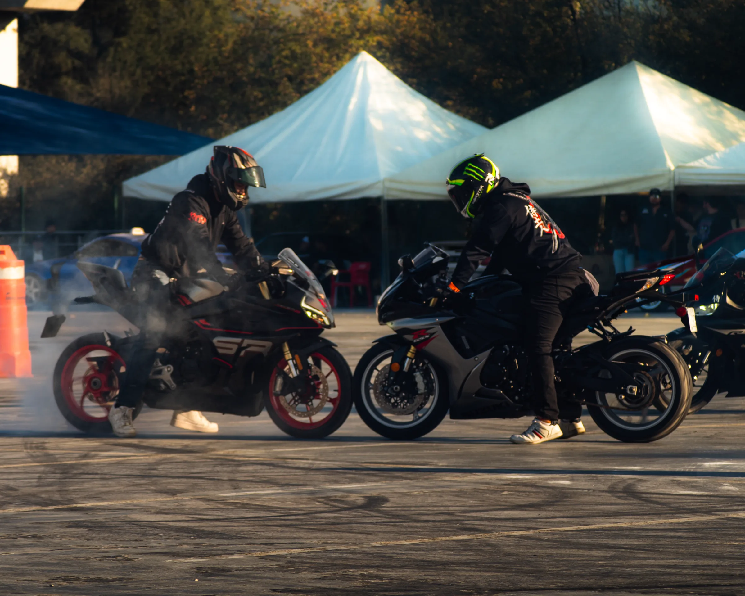 Dos motos y sus pilotos entre las carpas del paddock