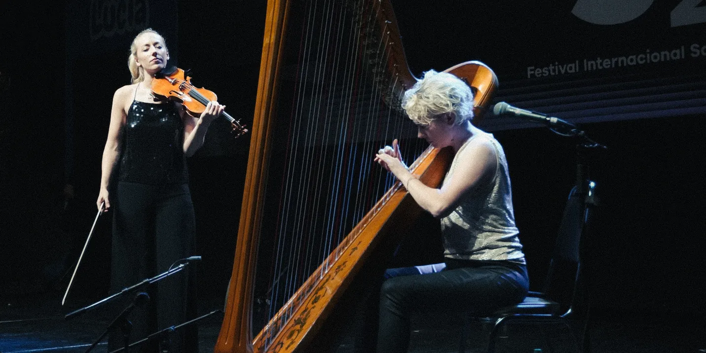 La violinista y la arpista tocan juntas en el teatro