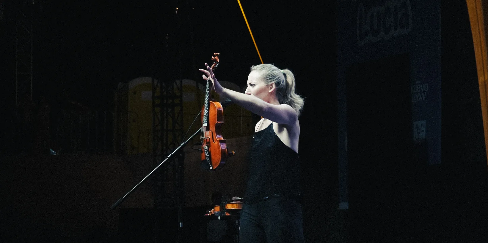 La violinista levanta el violín al terminar una pieza