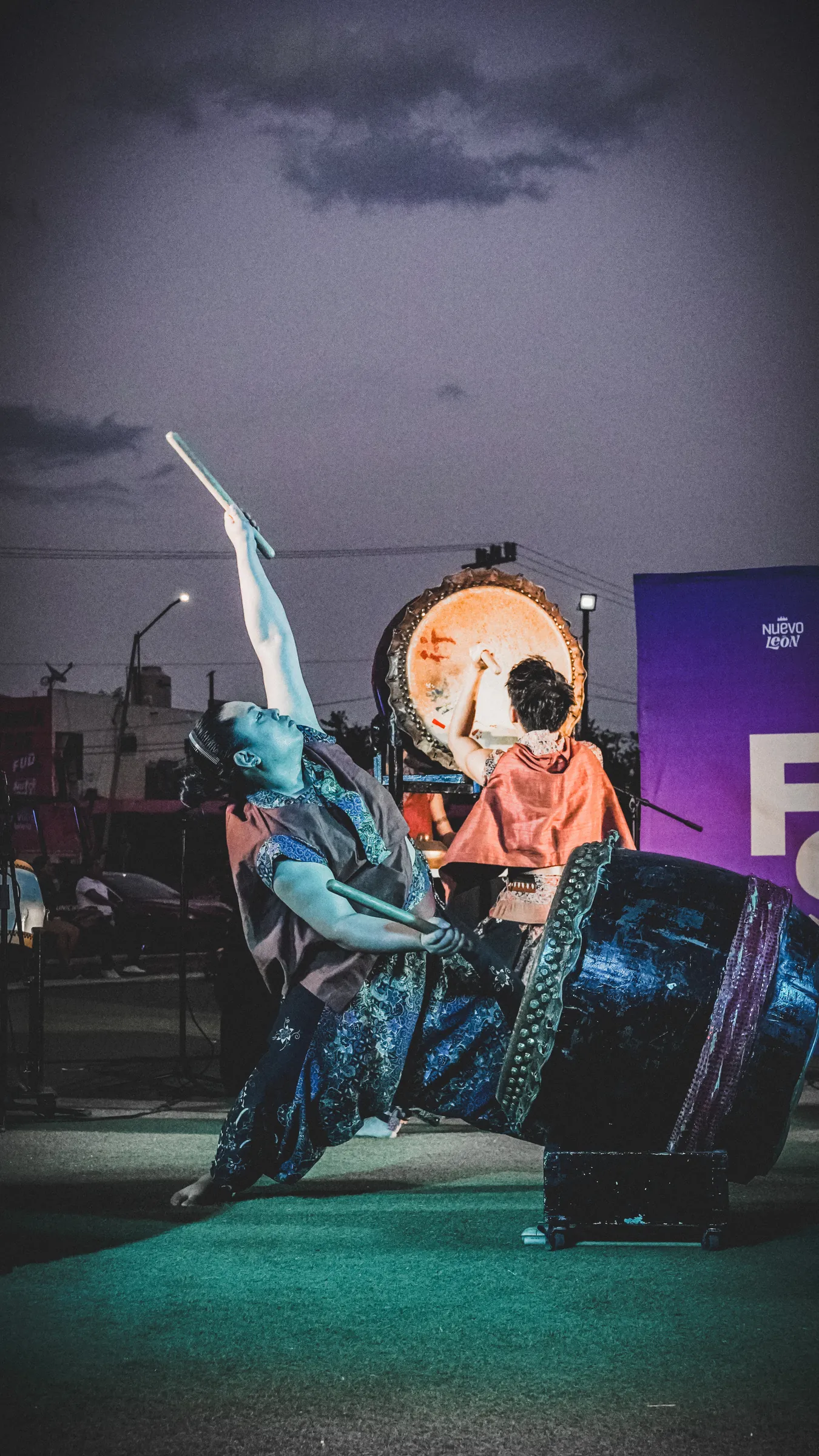 Un bailarín salta sobre el tambor, con el cielo morado detrás