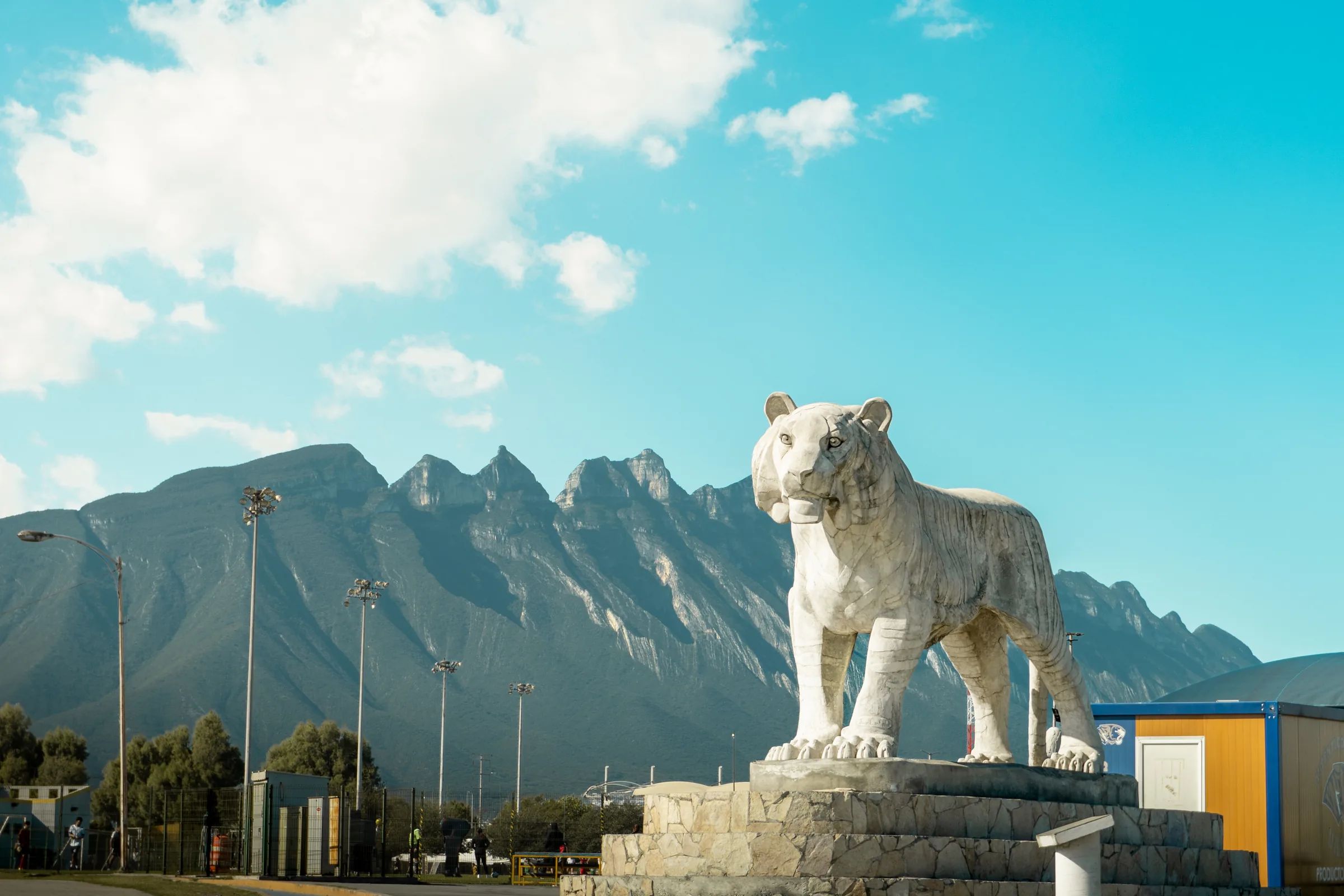 El tigre de piedra que recibe a Ciudad Universitaria, con el Cerro de la Silla detrás