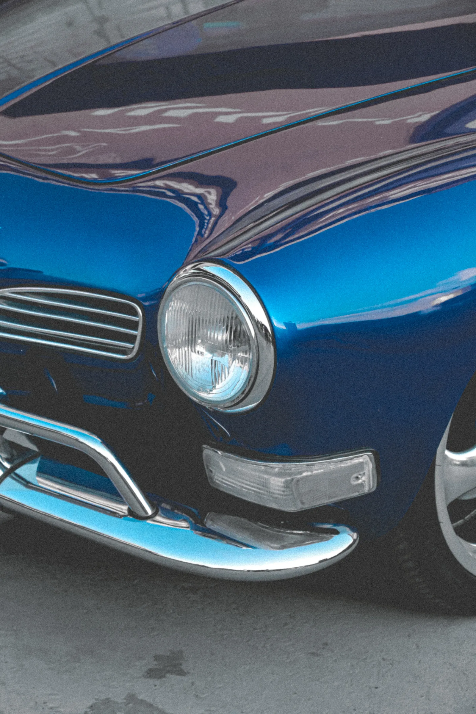 El cofre y el faro delantero del Karmann Ghia azul, con la defensa cromada