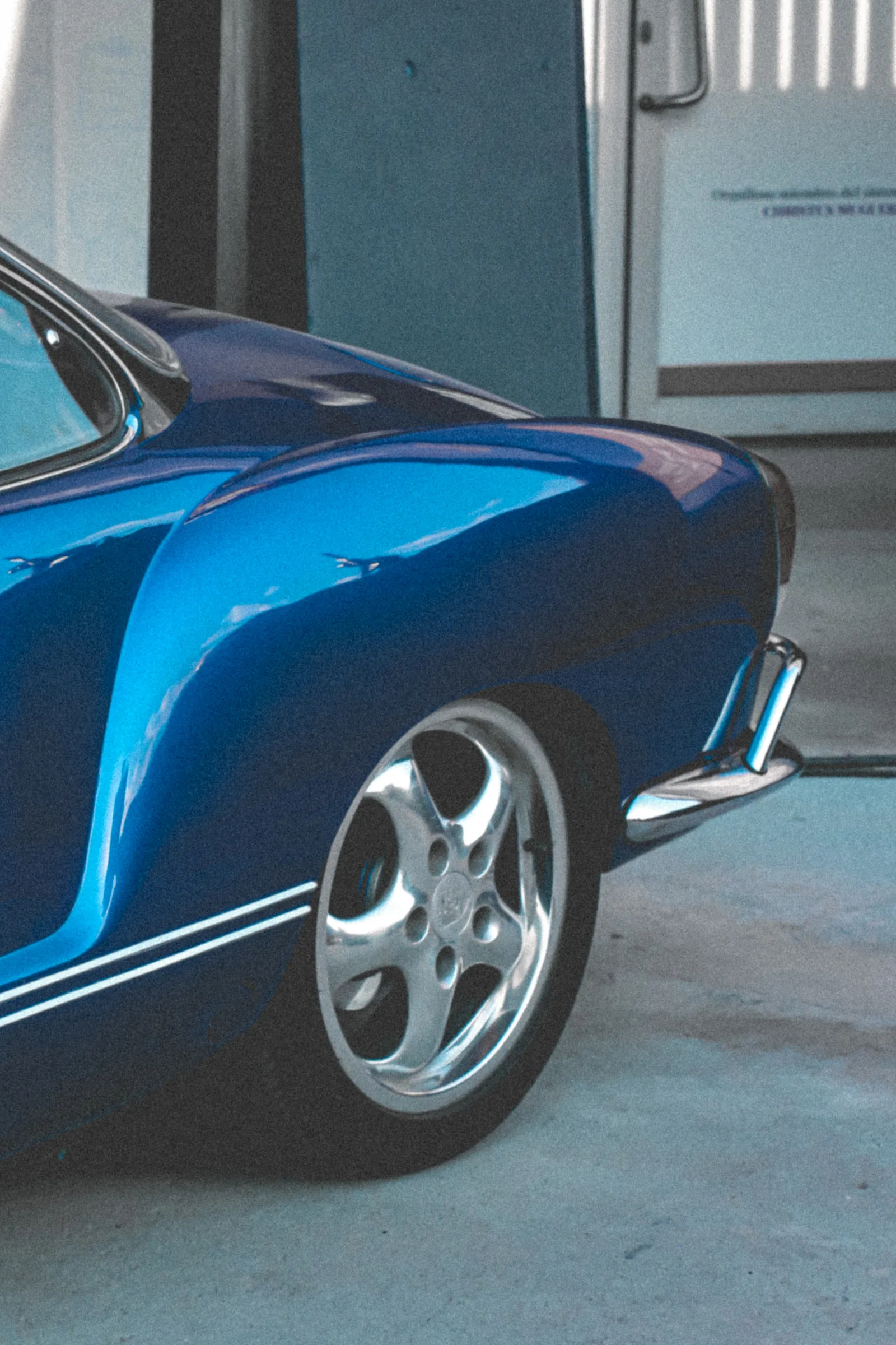 El rin cromado de rayos junto a la llanta trasera del Karmann Ghia