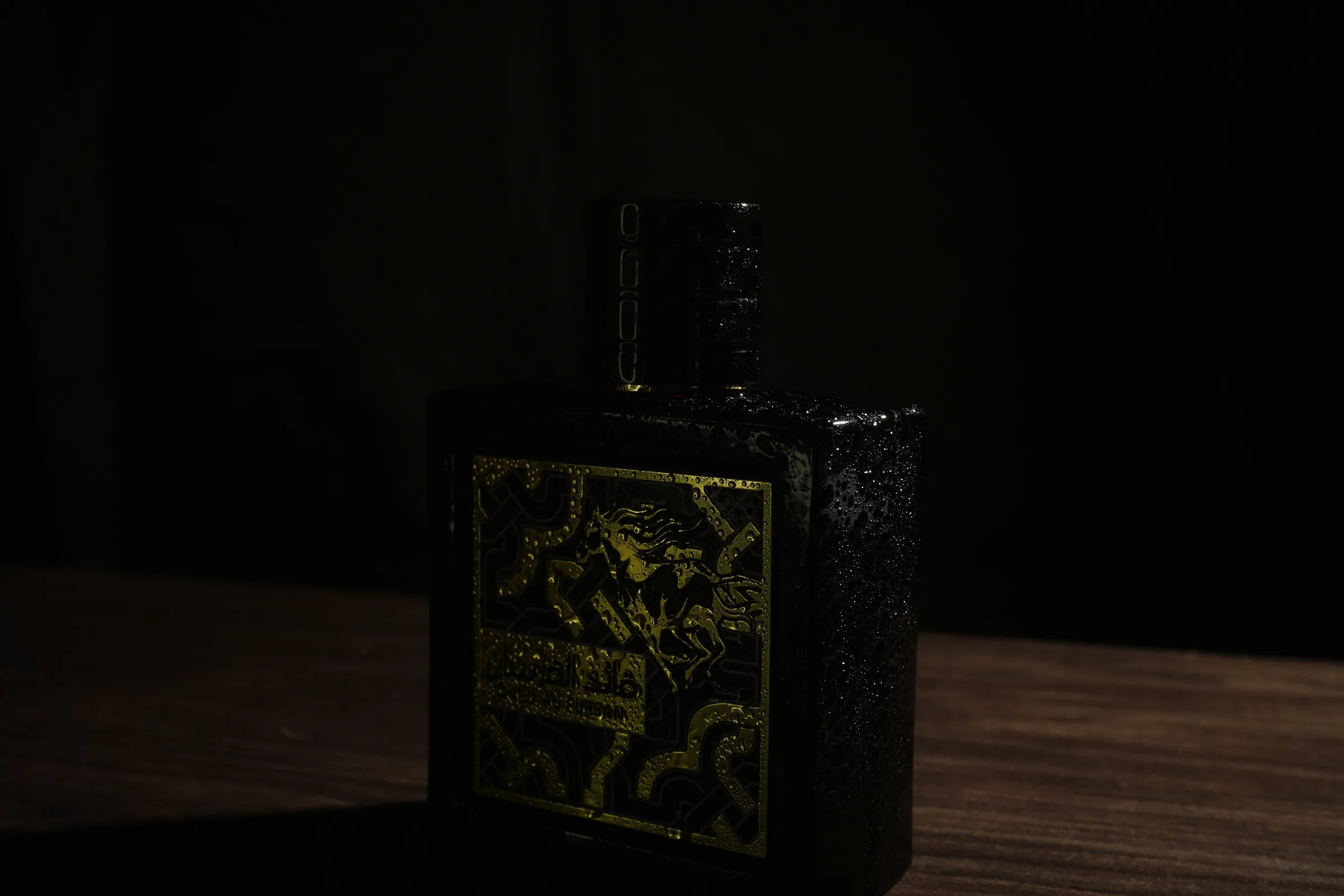 El caballo dorado de la etiqueta, en el frasco negro sobre la mesa de madera