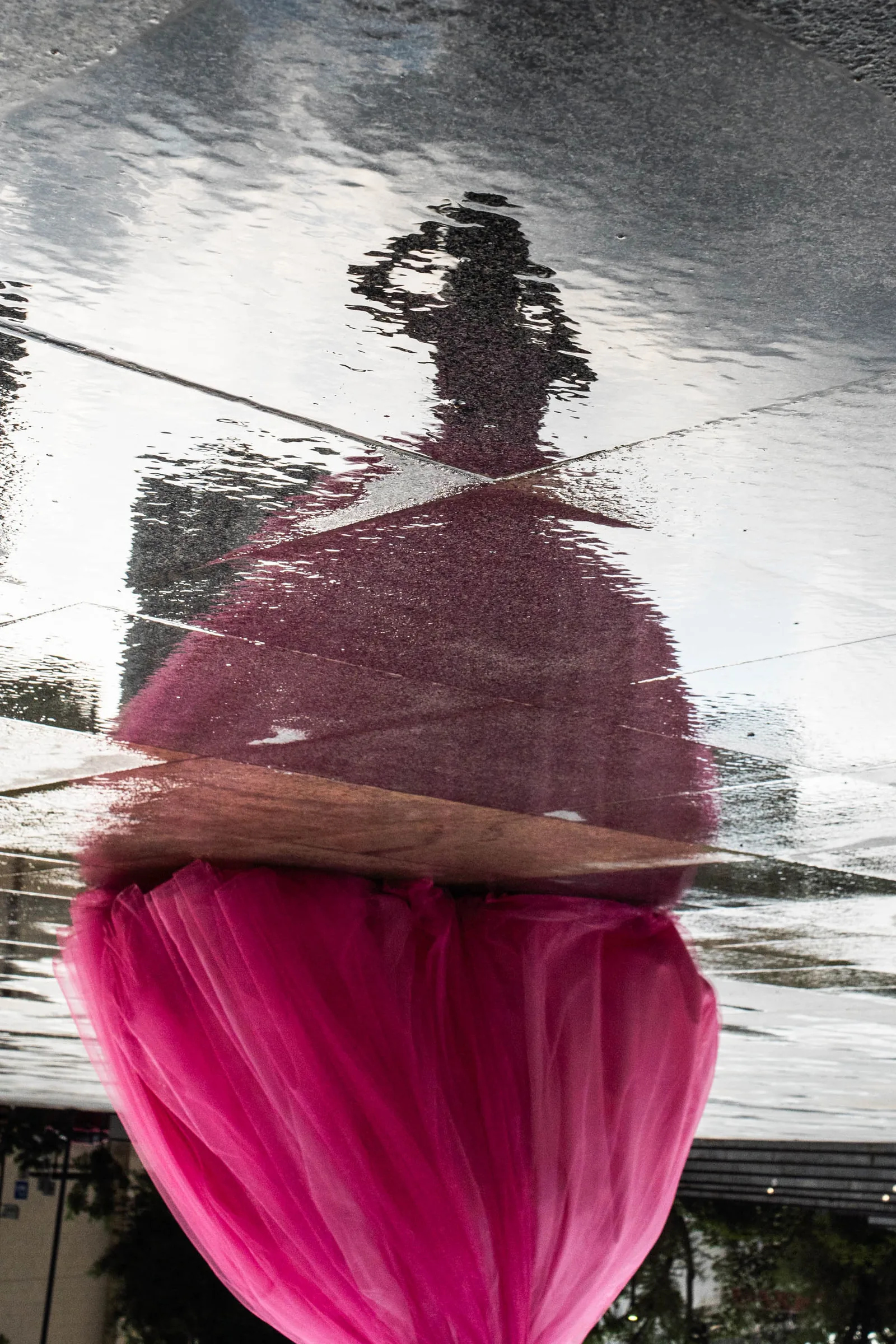 El reflejo de Arleth en un charco de la plaza, de cabeza